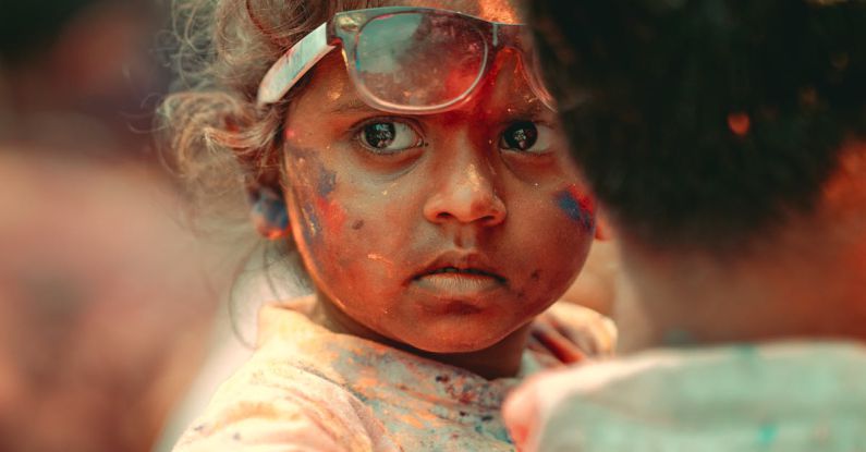 Family-Friendly Festivals - A child with paint on her face and a man